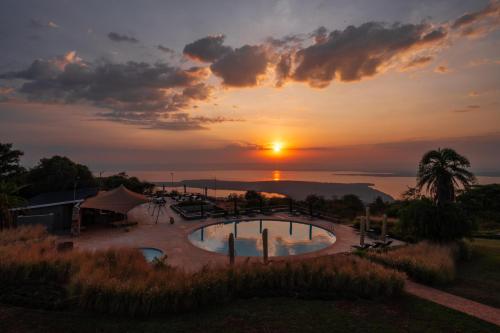 a sunset over a swimming pool at a resort at Mantis Akagera Game Lodge in Akagera