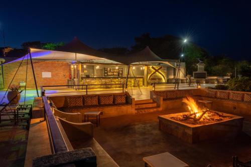 a patio with a fire pit at night at Mantis Akagera Game Lodge in Akagera