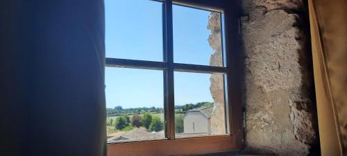a window with a view of a house at Le Fort d'Issigeac Chambres d'Hôtes in Issigeac