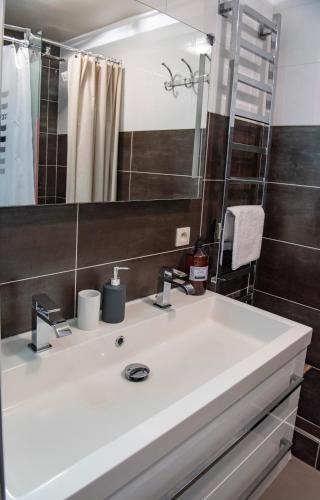 une salle de bain avec un lavabo blanc et un miroir dans l'établissement Quo Vadis - Proche plage et parking privé, à Arcachon