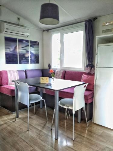 a dining room with a table and chairs and a couch at Villaggio Turistico Il Lago Dorato in Carlazzo