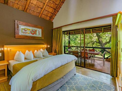 a bedroom with a large bed and a balcony at Leisure Time Rentals - Sanbonani Resort & Spa in Hazyview