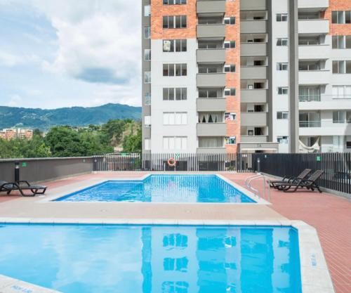 una piscina di fronte a un edificio di Sabaneta 22 a Sabaneta