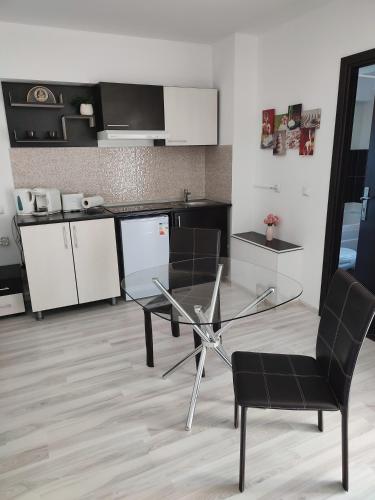 una cucina con tavolo in vetro e sedia di Sophia Central Studio a Iaşi