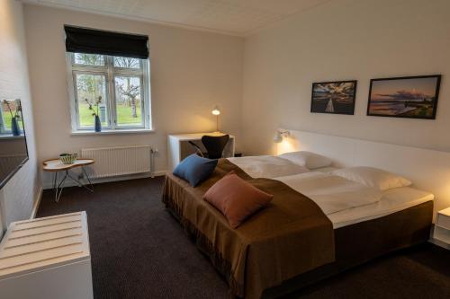 een slaapkamer met een groot bed en een raam bij Borre Knob konferencecenter in Juelsminde