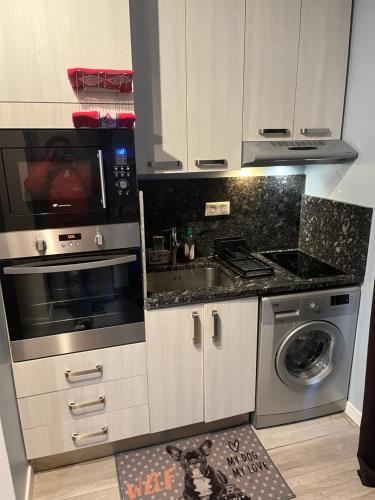 une cuisine avec une cuisinière et un micro-ondes dans l'établissement Jolie studio, à Rueil-Malmaison