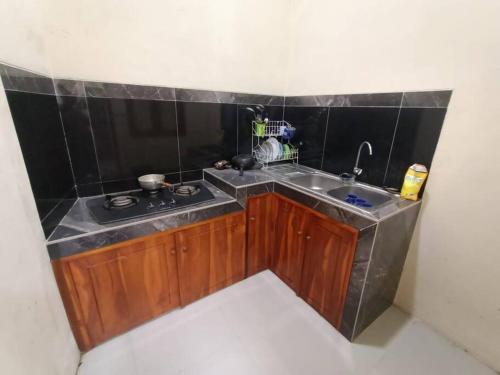 a small kitchen with a sink and a stove at Anugrah homestay in Cirebon