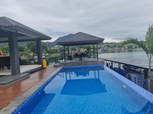 uma piscina ao lado de uma massa de água em PURNAMA BALIGE HOTEL em Balige