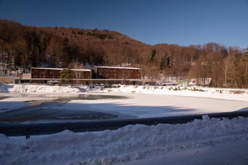 a snow covered field with a building in the background at SALAMANDRA Hotel in Banská Štiavnica