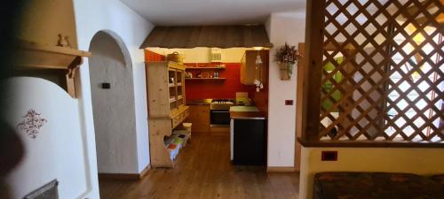 een keuken met rode muren en een houten vloer bij Chalet La Stua in Cavalese