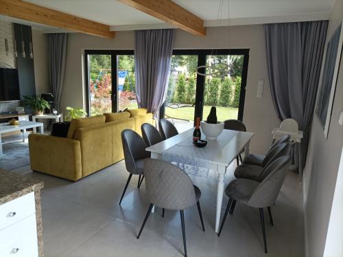 a living room with a white table and chairs at Całoroczny Domek Bielik Lubniewice,jakuzzi, jezioro,blisko SPA in Lubniewice