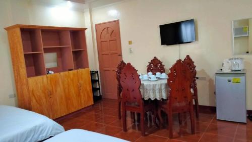 Cette chambre dispose d'une table, de chaises et d'une télévision. dans l'établissement CORALYN'S PLACE family of 6, à Boracay