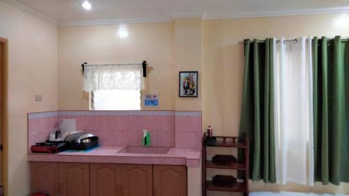 La salle de bains est pourvue d'un lavabo rose et d'une fenêtre. dans l'établissement CORALYN'S PLACE family of 6, à Boracay