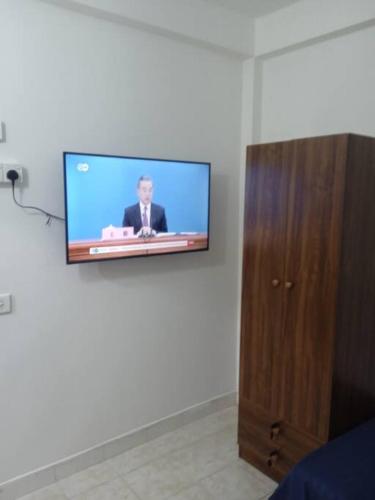 una TV a schermo piatto appesa a un muro in una camera di Three D please send an enquiry before booking a Città di Malé