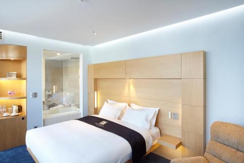 a hotel room with a bed and a chair at Eldis Regent Hotel in Daegu