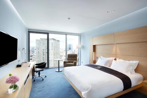 a hotel room with a bed and a desk with a television at Eldis Regent Hotel in Daegu