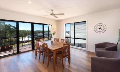 a dining room with a table and chairs and a balcony at Batemans Bay Delight - Pet Friendly in Batemans Bay