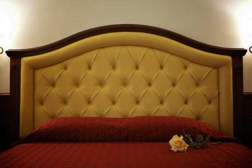 ローマにあるドムス アウグスタの赤いベッド1台、赤い枕が備わるベッドルーム1室が備わります。