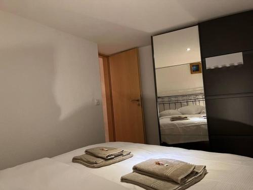 two towels sitting on top of a bed in a bedroom at Appartement rénové in Savièse