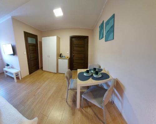 a dining room with a table and chairs and a kitchen at Jedrula in Łeba