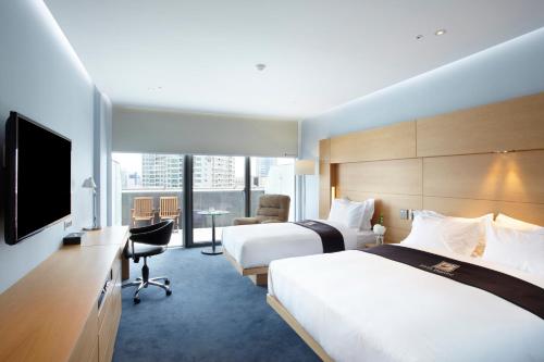 a hotel room with two beds and a flat screen tv at Eldis Regent Hotel in Daegu