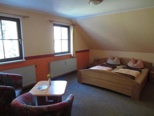 a hotel room with two beds and a table at Ferienwohnung Haus Sonnenblick in Luftkurort Lückendorf