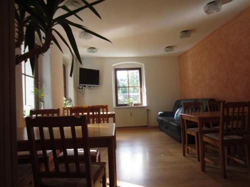 a living room with a table and chairs and a couch at Ferienwohnung Haus Sonnenblick in Luftkurort Lückendorf