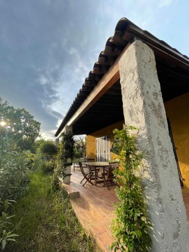 een patio met een tafel en stoelen op een huis bij Villa Maxime in Porto-Vecchio