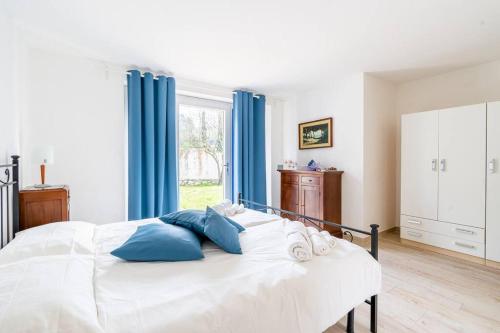a white bed with blue pillows in a bedroom at Rosemary’s Home in Quercianella
