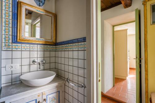 y baño con lavabo y espejo. en Melograni 4, en Molazzana