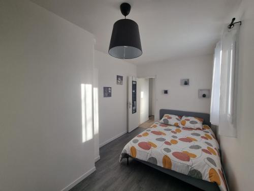 - une chambre avec un lit et une couette colorée dans l'établissement F2 cosy proche Disney et Paris, à Thorigny-sur-Marne