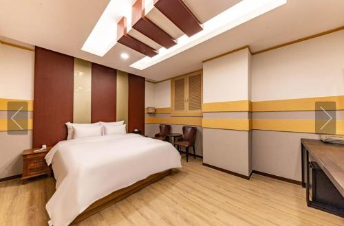 um quarto de hotel com uma cama e uma televisão em Cheonan Star Hotel em Cheonan