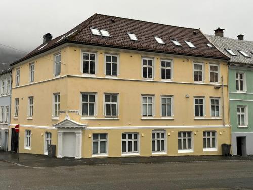 a large yellow building with a brown roof at Holmboe Apartment in Bergen