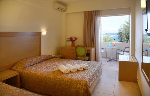 a hotel room with a bed and a balcony at Itanos in Sitia