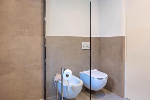 a bathroom with a toilet and a glass shower stall at Falsers Mountain Lodge in Cornedo all'Isarco