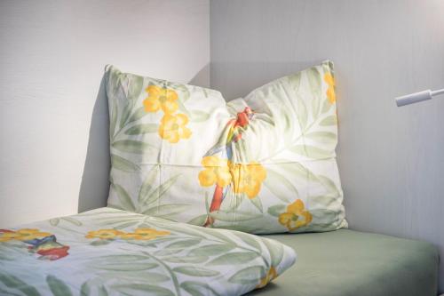 a pillow with a flower pattern on it next to a bed at Falsers Mountain Lodge in Cornedo all'Isarco