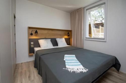 une chambre avec un lit et une fenêtre dans l'établissement Camping Etang de la Bonde, à Sannes