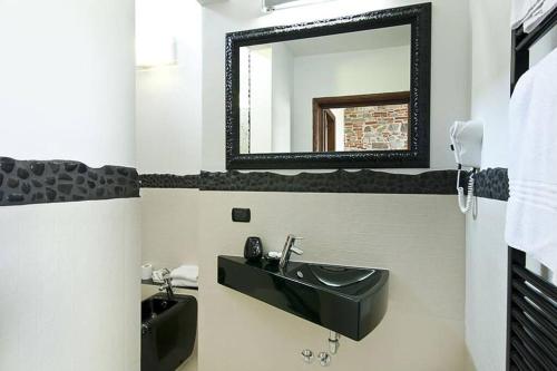 uma casa de banho com um lavatório preto e um espelho em Cozy Suite By Villa Il Mosaico em Florença