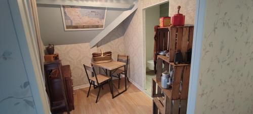 mały pokój z małym stołem i schodami w obiekcie L'ABRIGIT w mieście Curcy-sur-Orne
