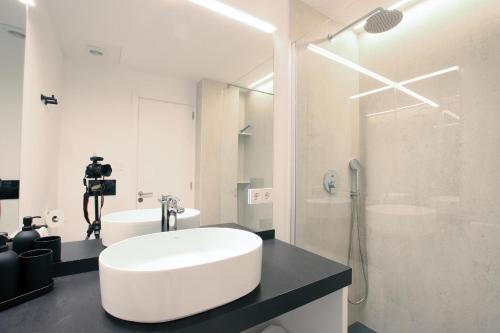 a white bathroom with a sink and a shower at Apartment Sivella in Pollença