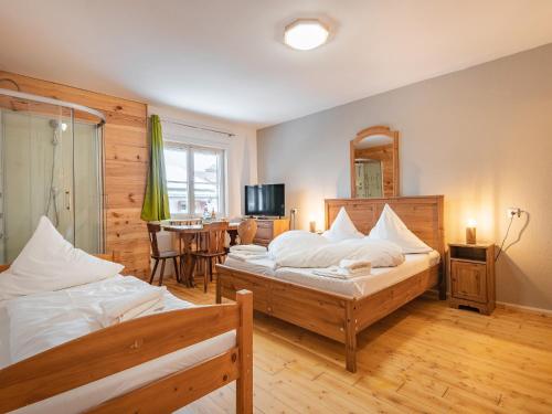 a bedroom with two beds and a dining room at Hostel - Ron`s Guesthouse in Oberstdorf