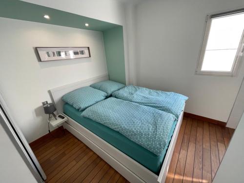 niewielka sypialnia z łóżkiem z niebieską pościelą w obiekcie Le Petit Pinson Meerblick Port Golfe Juan w mieście Vallauris
