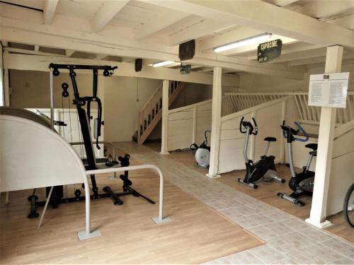 a gym with treadmills and exercise equipment in a building at Logis de L'Arceau in Celles