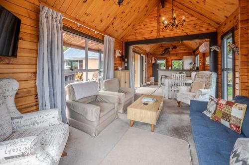 a living room with couches and a table at Maison en Noyer - Akaroa Holiday Home in Akaroa