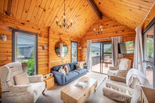 a living room with wooden walls and furniture in a cabin at Maison en Noyer - Akaroa Holiday Home in Akaroa