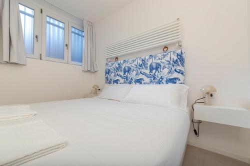 ein weißes Schlafzimmer mit einem blauen und weißen Bett in der Unterkunft I Host Apartment - Val Strona (2) in Mailand