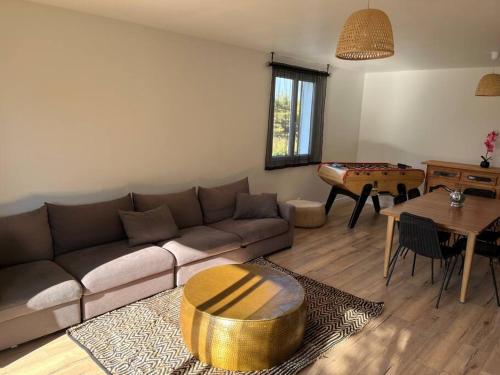 een woonkamer met een bank en een tafel bij Haut de villa avec jacuzzi et extérieur in Lançon-Provence