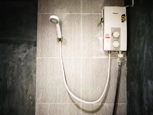 a shower with a white hose attached to a wall at Three Monkeys Bungalows Koh Yao Noi in Ko Yao Noi