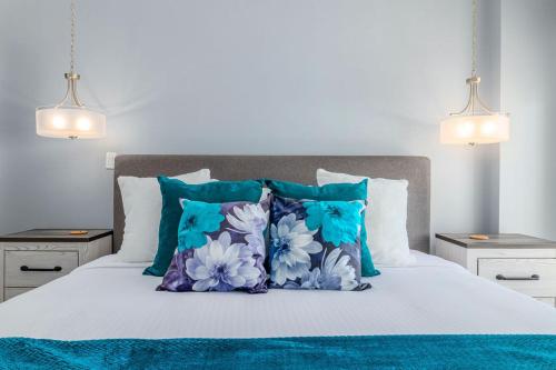 un lit avec des oreillers bleus et blancs dessus dans l'établissement Proper Design Beautiful View Ready To Enjoy, à Palm-Eagle Beach