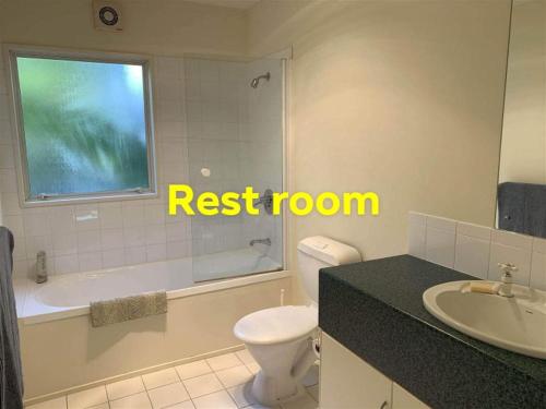 uma casa de banho com um WC, uma banheira e um lavatório. em Homestay, millions dollars view at Mount Pleasant em Christchurch
